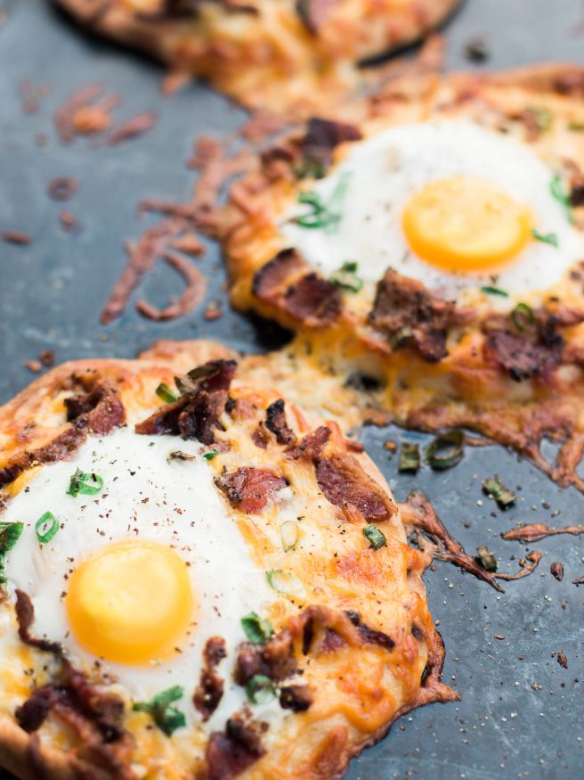 Breakfast pizza using Naan bread, loaded with cheese, bacon and topped with an egg! Hits the spot every morning!! 