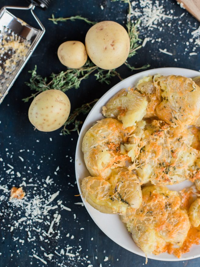 Smashed Potatoes smothered in a herb garlic butter with parmesan and cheddar cheese. Perfect comfort food side and is the best smashed potato recipe ever! 