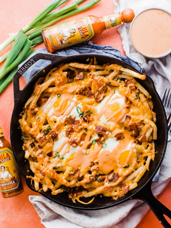 These loaded breakfast fries are topped with everything dreams are made of, bacon cheese, green onion, sunny side up eggs and a spicy aioli!