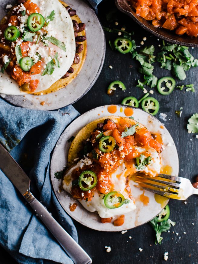 Huevos Rancheros Tostadas makes a great breakfast for dinner, or bunch meal. Topped with black beans, a from scratch salsa, then topped with a fried egg cojita cheese and serrano peppers