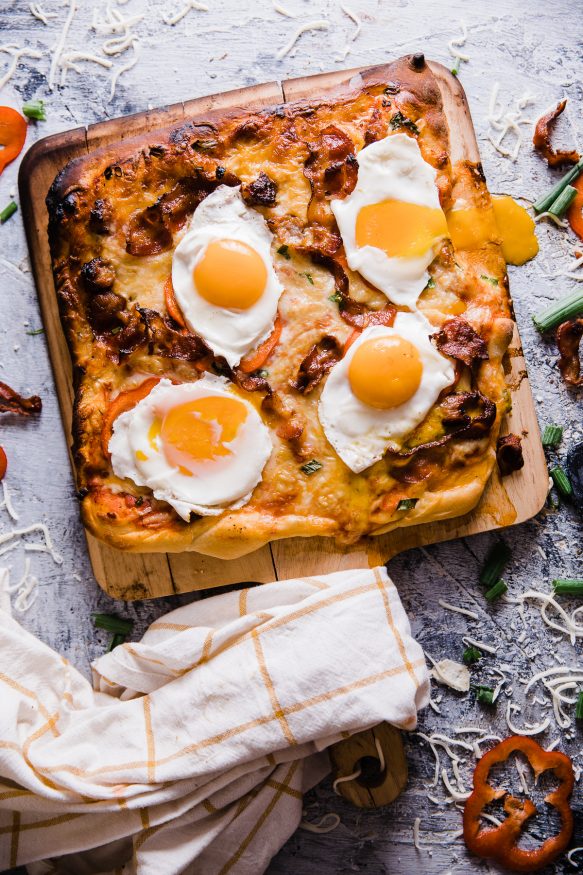 A delicious breakfast pizza loaded with bacon sausage, onion and red bell pepper, then topped with sunny side up eggs. Great weekend breakfast or a breakfast for dinner meal! 