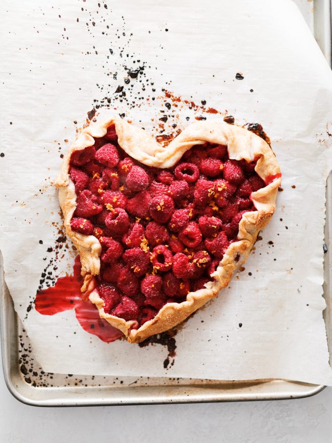 A raspberry galette in the shape of a heart. With raspberries, orange zest and a pre-made pie crust this makes the perfect Valentines Day dessert!