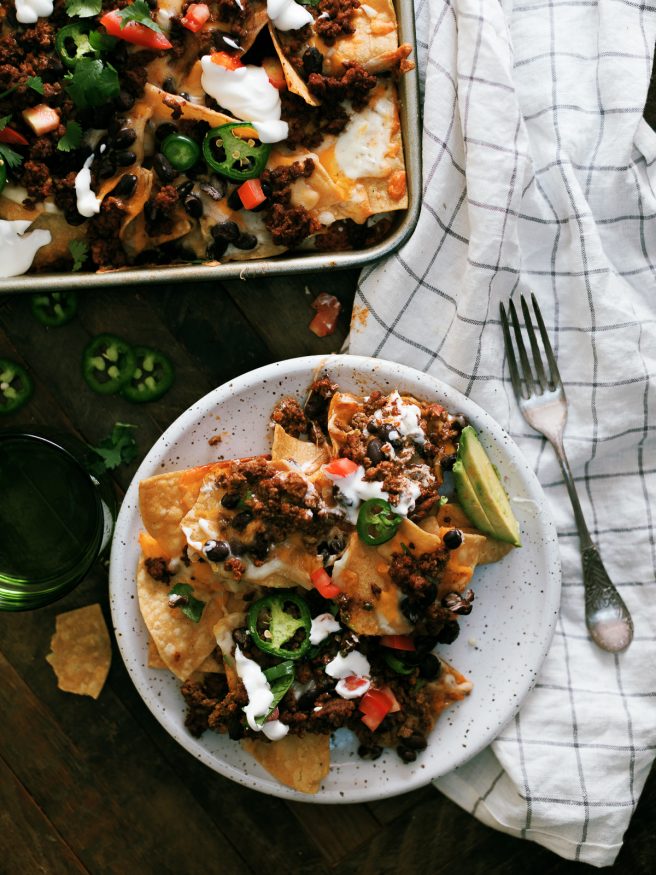 Taco Night Sheet Pan Nachos are a great way to put a spin on taco night. Taco seasoned ground beef and all your favorite taco toppings on sheet pan nachos.