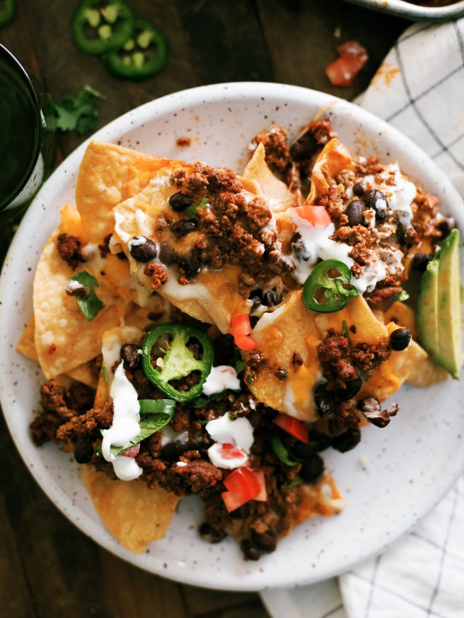 Taco Night Sheet Pan Nachos are a great way to put a spin on taco night. Taco seasoned ground beef and all your favorite taco toppings on sheet pan nachos.