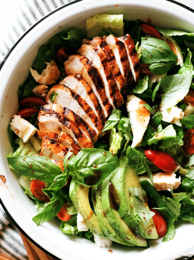 Grilled chicken caprese salad with balsamic marinaded chicken topped with fresh mozzarella, basil and cherry tomatoes. This is the perfect summer salad!