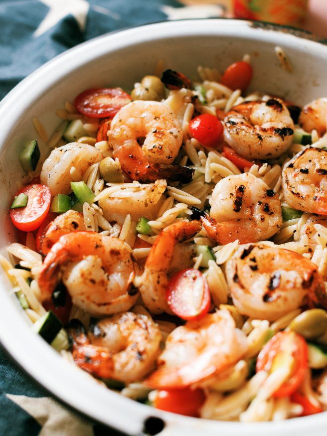 Zesty Grilled Shrimp, orzo pasta coated in an oil and vinegar based dressing with cucumber bell pepper cherry tomatoes. One of my favorite summer meals!