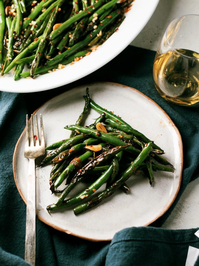 These blistered green beans are fried lightly in oil until blistered, then tossed in a spicy Asian cuisine inspired sauce that is out of this world! 