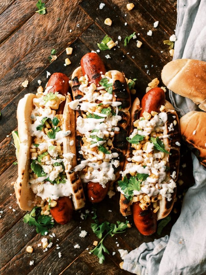 Grilled Andouille sausage hot dog, topped with grilled corn with a little elote seasoning, and a cilantro aioli. It's an explosion of flavors in one bite.