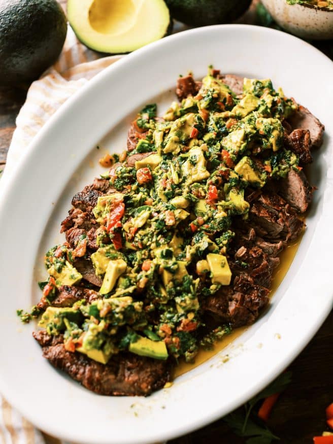 Grilled Flank Steak topped with an avocado chimichurri. This is an amazing summer grilled dinner that is fully of flavor!