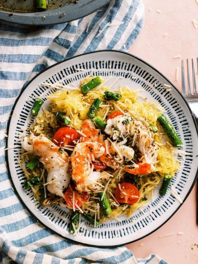 I'm going all out for this recipe and dressing up this spaghetti squash in pesto and topping with some grilled shrimp and asparagus!