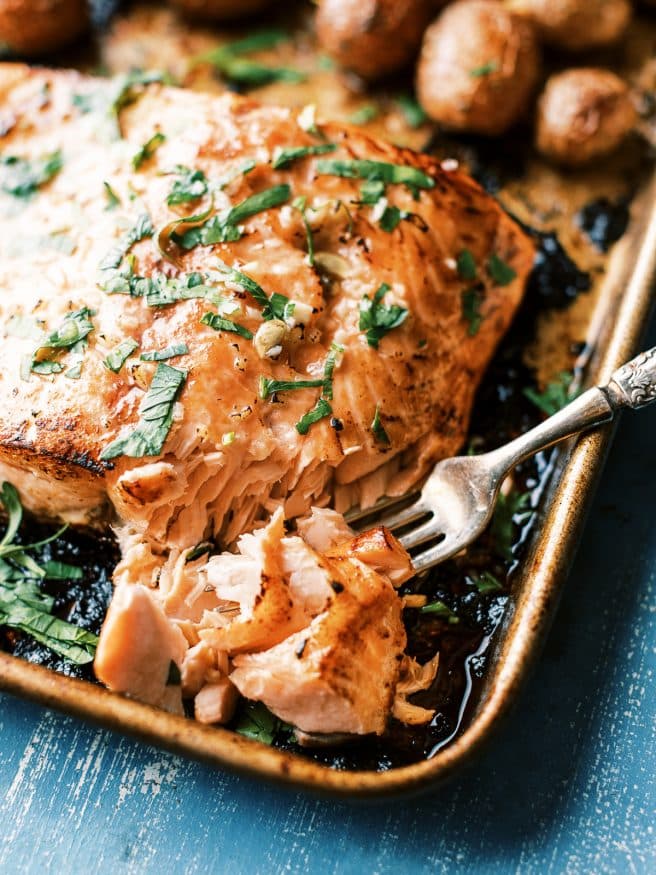 Easy weeknight Sheet Pan recipe with salmon glazed with a lemony honey butter garlic sauce served with baby red potatoes and broccoli. It's easy and a well rounded meal!